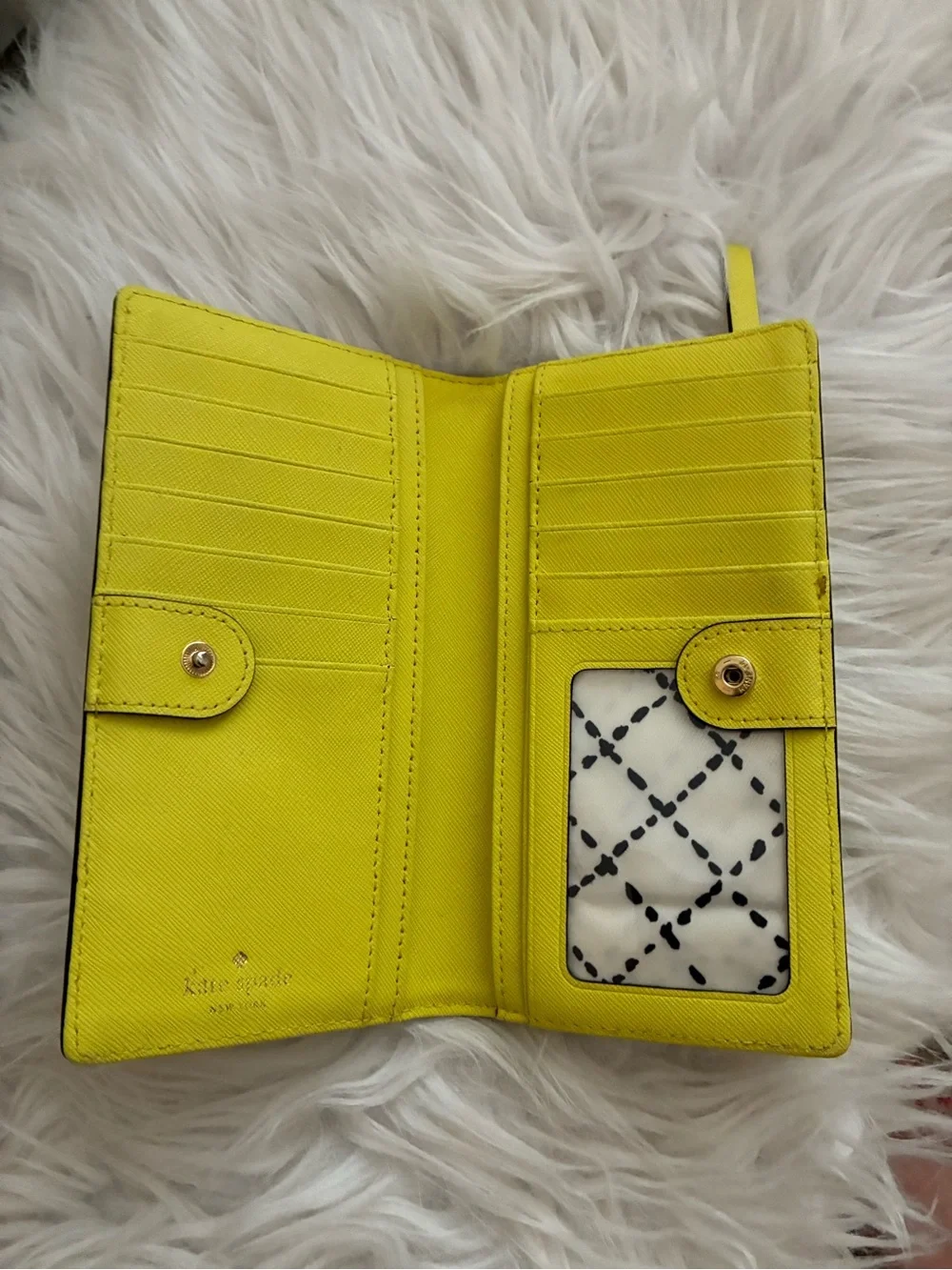 Lime green Kate Spade New York slim bifold wallet features multiple card slots